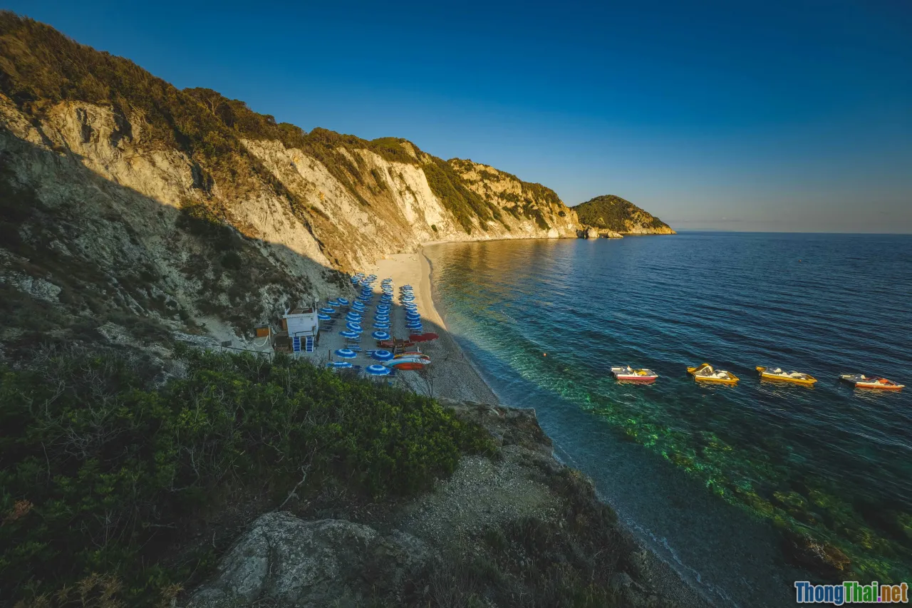 hidden beach, turquoise water, fishing village, coastal cliffs
